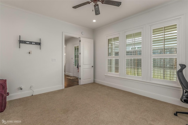 unfurnished office with carpet, a ceiling fan, ornamental molding, plenty of natural light, and baseboards