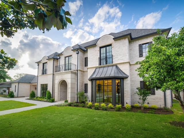 4633 Willow Ln, Dallas, TX 75244 - french provincial home featuring a balcony, brick siding, a front lawn, and a garage