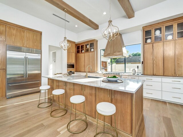 4633 Willow Ln, Dallas, TX 75244 - kitchen featuring appliances with stainless steel finishes, light wood-type flooring, beam ceiling, a kitchen breakfast bar, and a sink