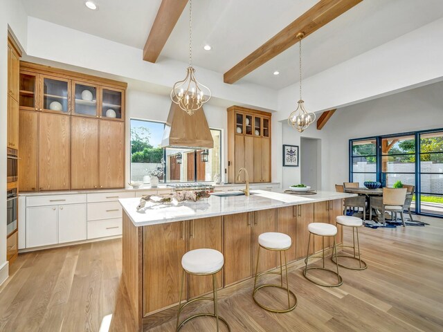 4633 Willow Ln, Dallas, TX 75244 - kitchen with a sink, beamed ceiling, light wood-style floors, a chandelier, and glass insert cabinets