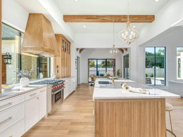 4633 Willow Ln, Dallas, TX 75244 - kitchen with island range hood, stainless steel range, a breakfast bar area, beamed ceiling, and a chandelier