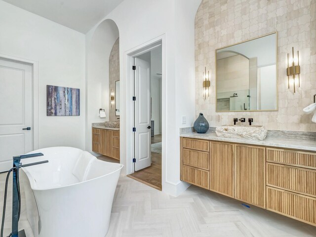 4633 Willow Ln, Dallas, TX 75244 - full bath with two vanities, a freestanding tub, and baseboards