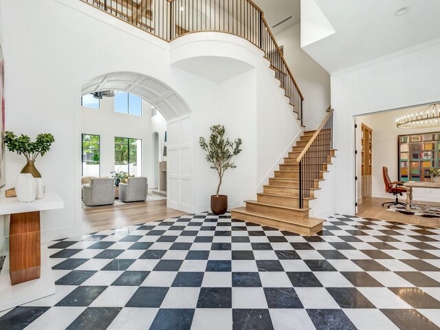 4633 Willow Ln, Dallas, TX 75244 - tiled entrance foyer with a high ceiling, arched walkways, a chandelier, and stairway