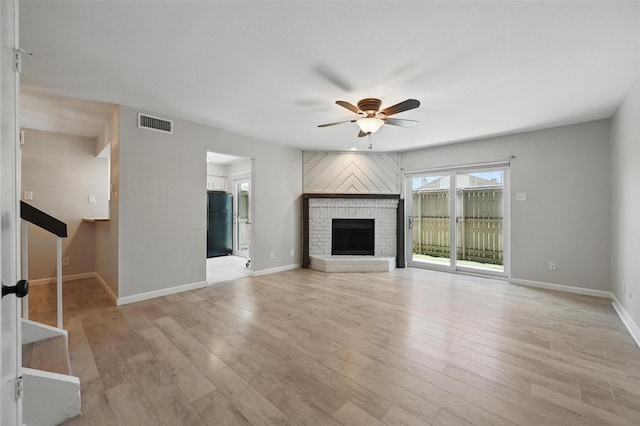 14800 Enterprise Dr Unit 17A, Farmers Branch, TX 75234 - unfurnished living room featuring a ceiling fan, light wood finished floors, baseboards, and a brick fireplace