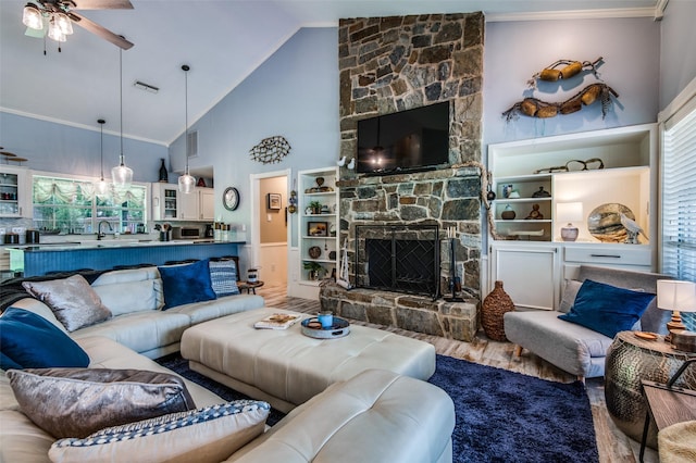 6500 Brenda, Malakoff, TX 75148 - living area featuring wood finished floors, a ceiling fan, a stone fireplace, ornamental molding, and high vaulted ceiling
