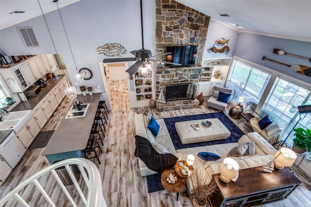6500 Brenda, Malakoff, TX 75148 - living room with crown molding, wood finished floors, a stone fireplace, high vaulted ceiling, and a ceiling fan