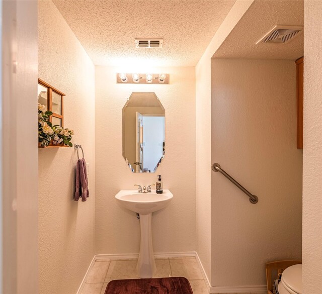5929 Meadowcrest Ln, Sachse, TX 75048 - bathroom with a textured ceiling, tile patterned floors, toilet, baseboards, and a textured wall