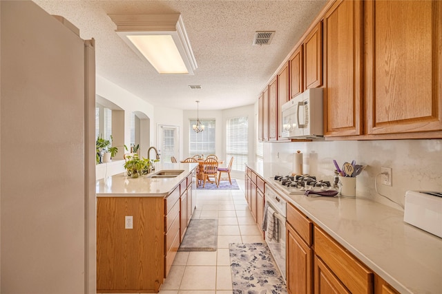 5929 Meadowcrest Ln, Sachse, TX 75048 - kitchen with white appliances, a sink, a textured ceiling, light countertops, and light tile patterned flooring