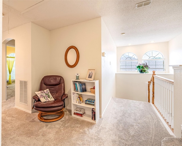 5929 Meadowcrest Ln, Sachse, TX 75048 - sitting room featuring carpet floors, arched walkways, baseboards, and a textured ceiling
