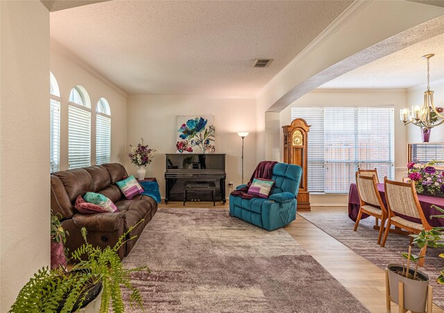 5929 Meadowcrest Ln, Sachse, TX 75048 - living area with a textured ceiling, wood finished floors, a chandelier, and crown molding