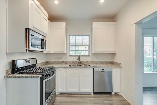 4423 Colonial Ave, Dallas, TX 75215 - kitchen with appliances with stainless steel finishes, a sink, light wood-style floors, light stone countertops, and recessed lighting
