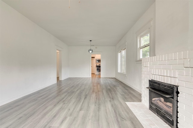 4423 Colonial Ave, Dallas, TX 75215 - unfurnished living room with light wood-style flooring, a fireplace, and baseboards