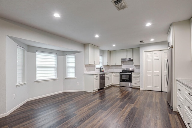 7824 Daniel Dr, North Richland Hills, TX 76182 - kitchen with stainless steel appliances, under cabinet range hood, dark wood-type flooring, baseboards, and light stone counters