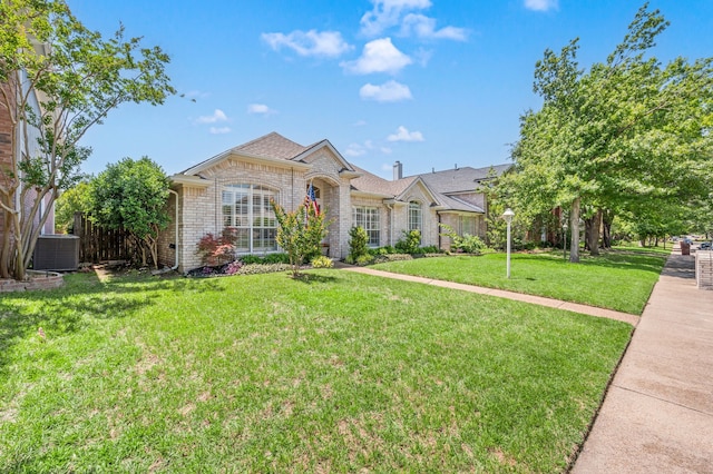 4252 Millview Ln, Dallas, TX 75287 - view of front facade with brick siding, a front lawn, and cooling unit