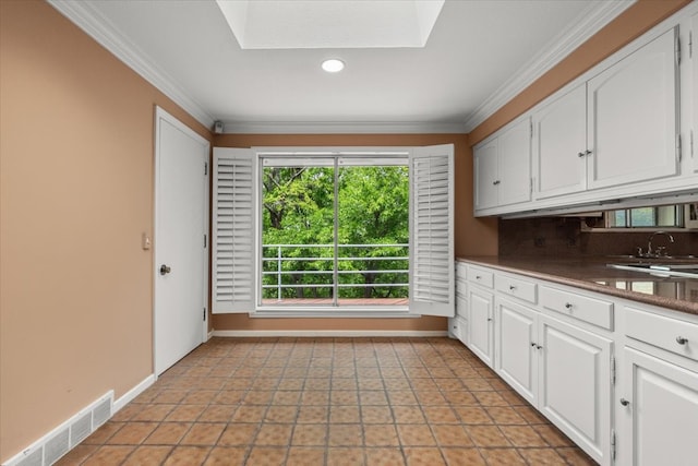 2900 Simondale Dr, Fort Worth, TX 76109 - kitchen with crown molding, baseboards, white cabinets, dark countertops, and recessed lighting