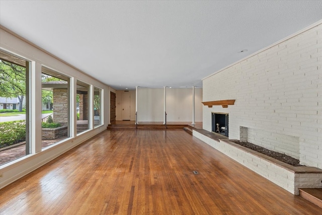 2900 Simondale Dr, Fort Worth, TX 76109 - unfurnished living room with a brick fireplace, wood finished floors, and baseboards