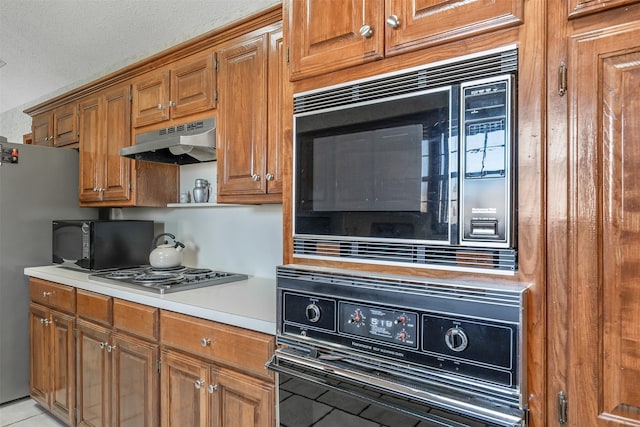 17881 Silver Leaf, Flint, TX 75762 - kitchen featuring black appliances, under cabinet range hood, light countertops, and brown cabinets