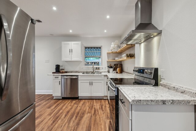 3351 Santa Teresa Ave, Dallas, TX 75228 - kitchen featuring appliances with stainless steel finishes, wall chimney range hood, a sink, light wood-style floors, and light countertops