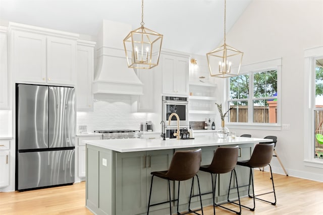 2410 Somercrest Pl, Midlothian, TX 76065 - kitchen with appliances with stainless steel finishes, a chandelier, custom exhaust hood, a kitchen island with sink, and light countertops