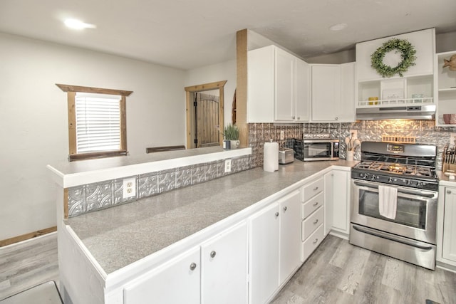 179 Oak St, Nocona, TX 76255 - kitchen featuring stainless steel appliances, under cabinet range hood, light wood-type flooring, white cabinets, and decorative backsplash