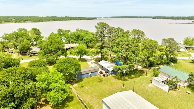 179 Oak St, Nocona, TX 76255 - rear view of property with a lawn, a sunroom, and metal roof