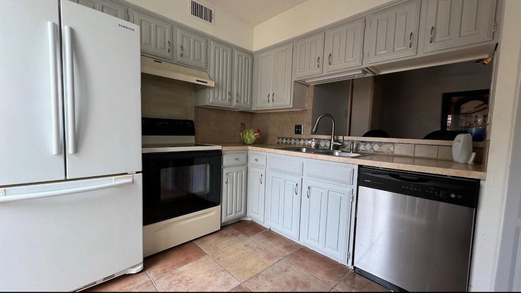 883 Dublin Dr Unit 1, Richardson, TX 75080 - kitchen featuring freestanding refrigerator, dishwasher, electric range oven, under cabinet range hood, and a sink