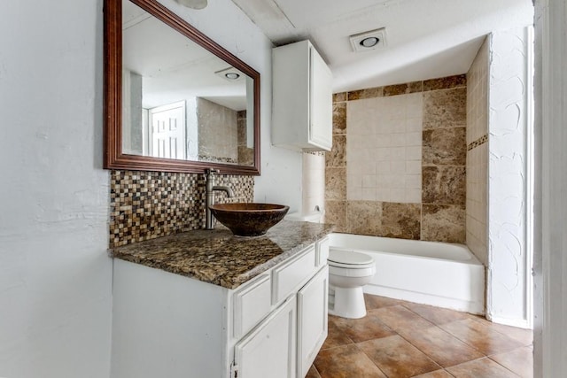 9601 Forest Ln Unit 822, Dallas, TX 75243 - bathroom with toilet, vanity, and decorative backsplash