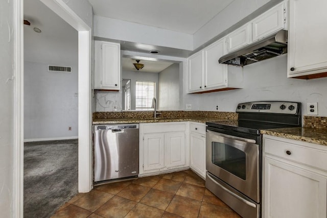 9601 Forest Ln Unit 822, Dallas, TX 75243 - kitchen with stainless steel appliances, under cabinet range hood, a sink, white cabinetry, and dark stone countertops