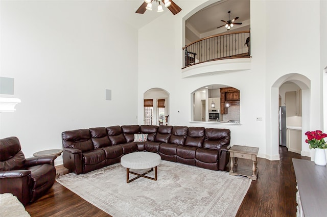 968 Fairfield Ln, Allen, TX 75013 - living area with ceiling fan, dark wood finished floors, baseboards, a towering ceiling, and arched walkways