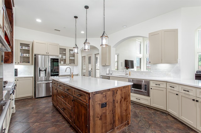 968 Fairfield Ln, Allen, TX 75013 - kitchen featuring appliances with stainless steel finishes, a sink, arched walkways, glass insert cabinets, and backsplash