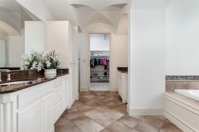 968 Fairfield Ln, Allen, TX 75013 - bathroom featuring vanity, a bath, a walk in closet, and baseboards