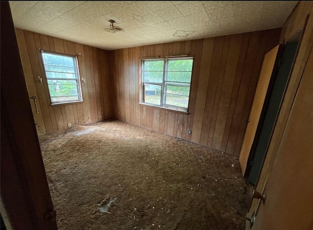 307 N 4th St, Crandall, TX 75114 - empty room featuring healthy amount of natural light and wooden walls