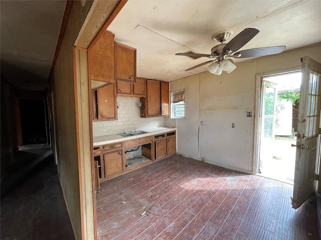 307 N 4th St, Crandall, TX 75114 - kitchen with brown cabinetry, tile countertops, tasteful backsplash, dark wood-style floors, and a ceiling fan