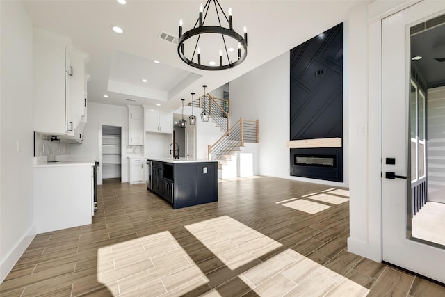 9320 Beckleycrest Ave, Dallas, TX 75232 - kitchen featuring wood finish floors, a chandelier, white cabinetry, light countertops, and open floor plan