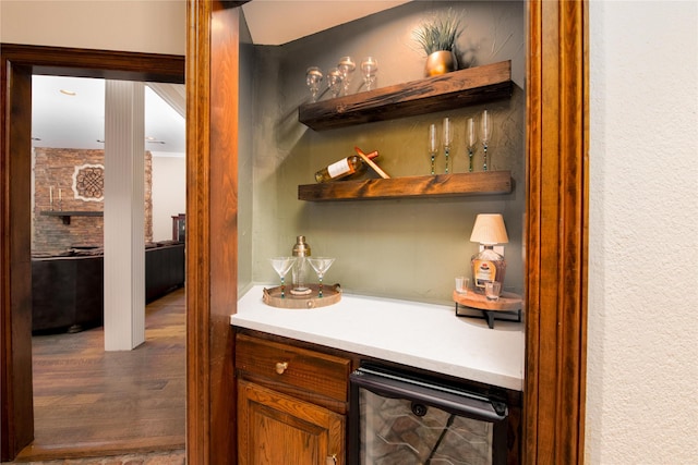 indoor dry bar featuring wine cooler and wood finished floors