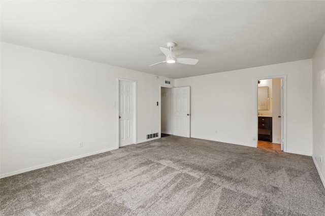 unfurnished bedroom featuring carpet floors, baseboards, ensuite bath, and a ceiling fan