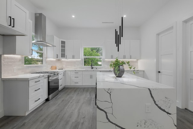 1921 Pollard St, Dallas, TX 75208 - kitchen with island exhaust hood, gas stove, light wood-type flooring, light stone counters, and recessed lighting