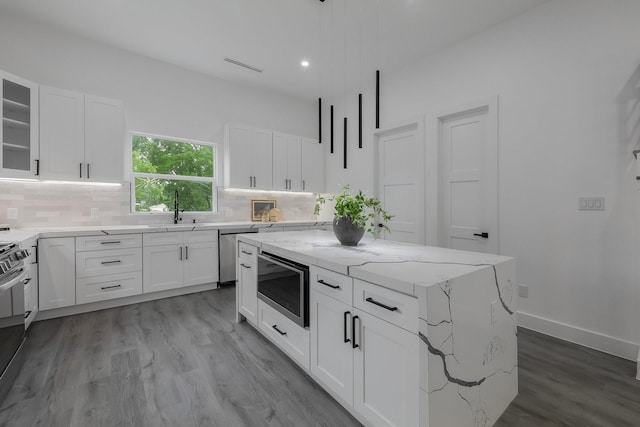 1921 Pollard St, Dallas, TX 75208 - kitchen featuring appliances with stainless steel finishes, a sink, tasteful backsplash, light stone countertops, and wood finished floors