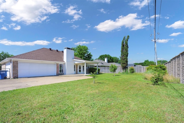view of yard featuring a garage and concrete driveway