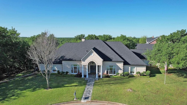 1706 Kiowa, Graham, TX 76450 - french country home featuring a front lawn, a chimney, and a shingled roof