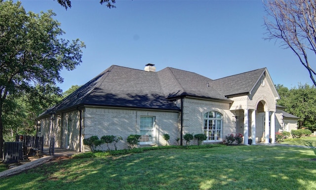 1706 Kiowa, Graham, TX 76450 - rear view of house featuring a lawn, brick siding, a chimney, and central AC