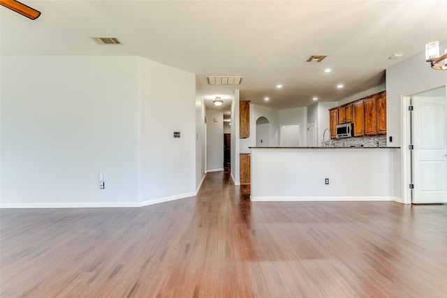 2007 Brazoria Dr, Forney, TX 75126 - kitchen with stainless steel microwave, arched walkways, wood finished floors, open floor plan, and recessed lighting