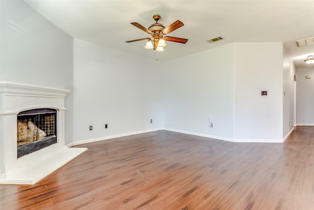 2007 Brazoria Dr, Forney, TX 75126 - unfurnished living room featuring a ceiling fan, a fireplace with raised hearth, wood finished floors, and baseboards