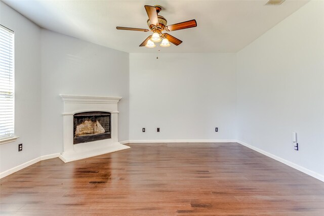 2007 Brazoria Dr, Forney, TX 75126 - unfurnished living room with ceiling fan, healthy amount of natural light, a fireplace with raised hearth, and wood finished floors