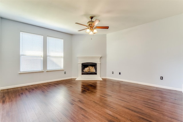 2007 Brazoria Dr, Forney, TX 75126 - unfurnished living room with ceiling fan, a fireplace with raised hearth, wood finished floors, and baseboards