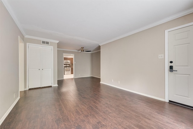 unfurnished living room with dark wood-style flooring, ornamental molding, baseboards, and ceiling fan