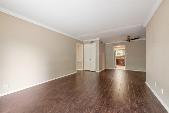 spare room featuring wood finished floors, a ceiling fan, baseboards, and crown molding