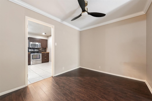 spare room with light wood-style floors, ornamental molding, a ceiling fan, and baseboards