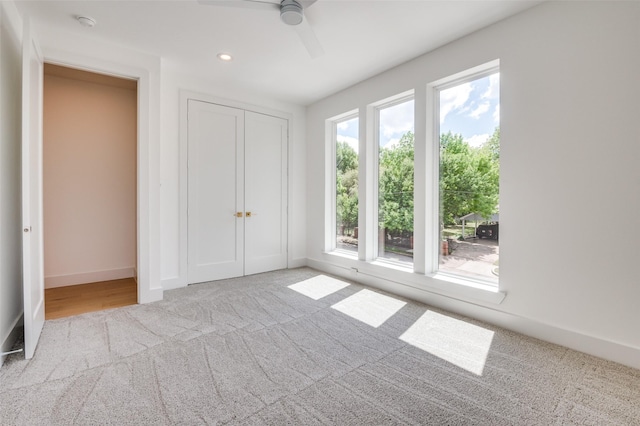 unfurnished bedroom featuring carpet flooring, baseboards, a closet, a ceiling fan, and recessed lighting