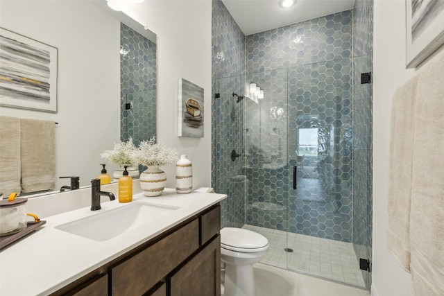 bathroom featuring a shower stall, toilet, and vanity